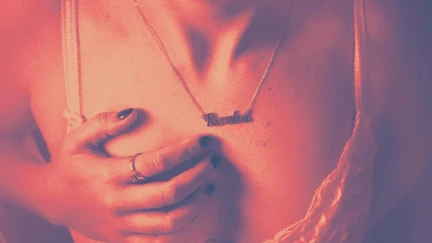 A person with their hand on their chest, wearing a necklace that says Revulva.