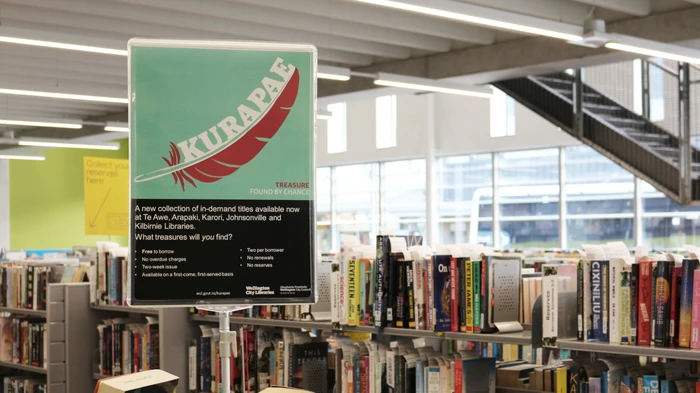 A bookshelf with a poster for our Kurapae collection.