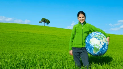 Image showing child in field holding globe