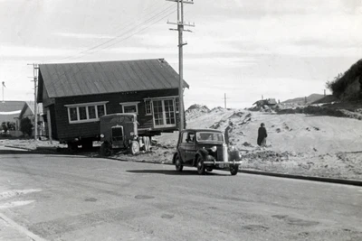 Basic wooden house propped on a truck to be relocated.