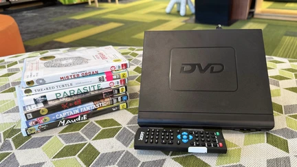 DVD Player, remote control, and stack of DVDs