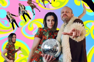 Sacha and Josh, dressed in disco clothes and holding a disco ball, pose in front of a colourful background of swirling blues, pinks, and yellows