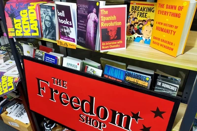 Book display. Large red sign saying "The Freedom Shop" with an image of three stars next to the words with a shelf above of books.