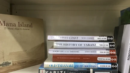 Books lying flat on library shelf