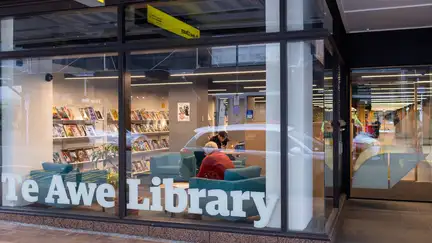 Panama Street entrance to Te Awe Library, with magazine display shelves visible through the window