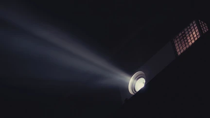 A movie projector throwing light across a darkened room