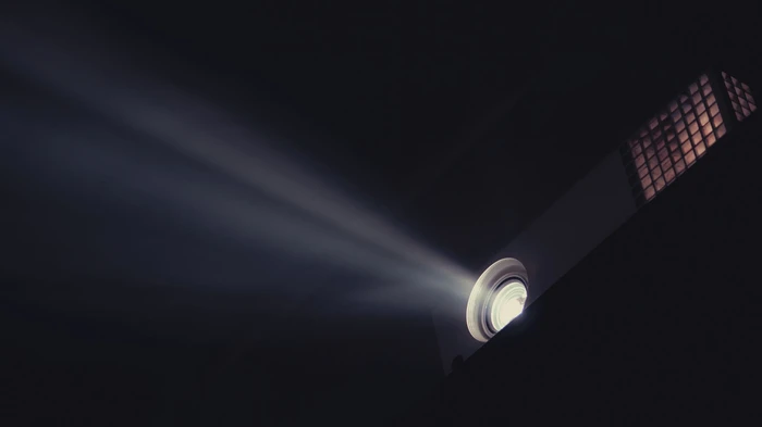 A movie projector throwing light across a darkened room