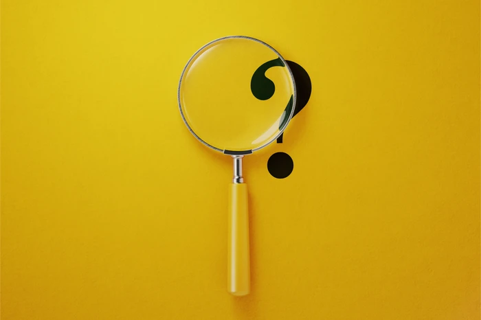 a magnifying glass and a question mark on a yellow background.