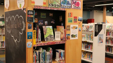 An image of the children's section at Te Awe Library, with the kids' te reo collection at the centre on wooden shelves.