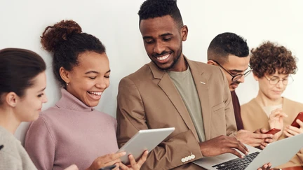 People in business casual, networking with their devices at a conference