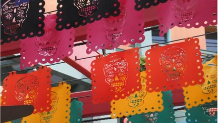 Día de los Muertos colourful flags hanging in rows outside a building